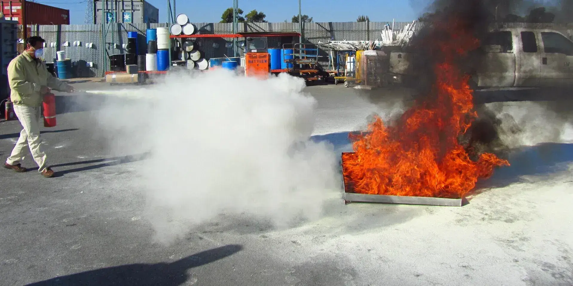ABC Fire Protection team demonstrating fire extinguisher use in an industrial lot